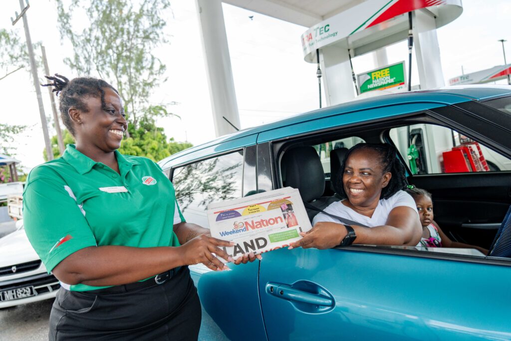 Kendal Hill RUBIS Service Ambassador Glendine presenting a happy customer with her free Nation newspaper.